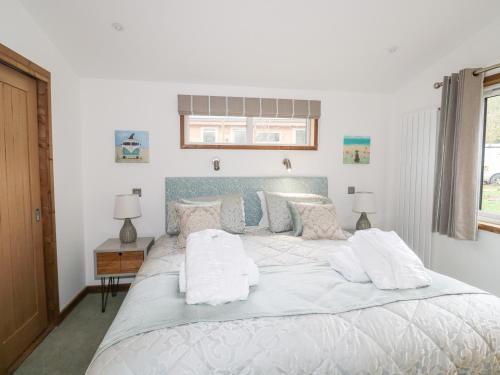 a bedroom with a large white bed with pillows at 1 Valley View in Looe