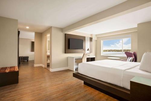 a bedroom with a large bed and a television at Wyndham Newport Hotel in Middletown