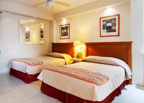 Una cama o camas en una habitación de Hotel y Suites Nader