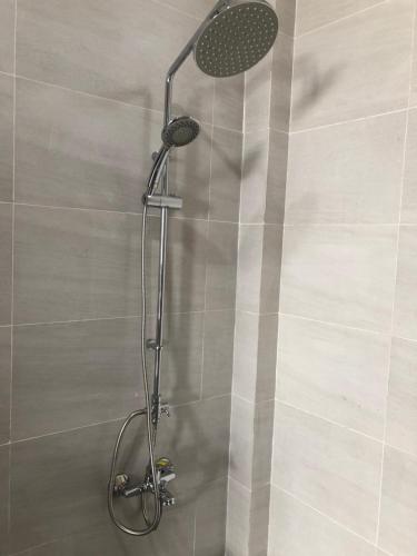 a shower with a shower head in a bathroom at BIỂN ĐỒI Bungalow in Phu Quoc