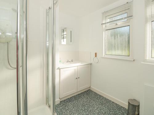 ein weißes Badezimmer mit Dusche und Waschbecken in der Unterkunft 304 Norton Park in Dartmouth