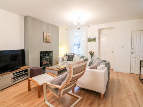 a living room with a couch and a tv at Yr Adfa The Retreat in Blaenau-Ffestiniog