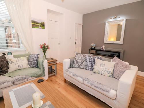 a living room with two couches and a fireplace at Yr Adfa The Retreat in Blaenau-Ffestiniog