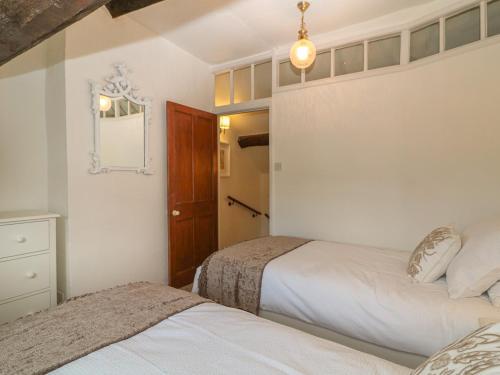 a bedroom with two beds and a mirror on the wall at Dolphin House in Burford
