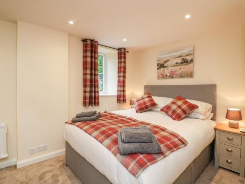 ein Schlafzimmer mit einem Bett mit zwei Kissen darauf in der Unterkunft Tilly's Cottage in Westbury