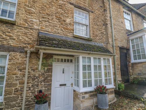 a brick house with a white door and windows at Dolphin House in Burford