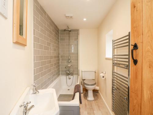 ein Badezimmer mit Badewanne, Toilette und Waschbecken in der Unterkunft Tilly's Cottage in Westbury