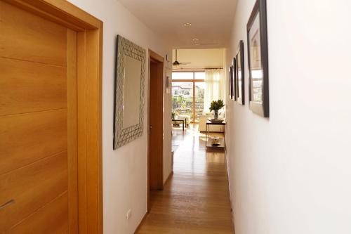 a hallway with wooden floors and pictures on the walls at Sybaris Suites & Residences in Juan Dolio