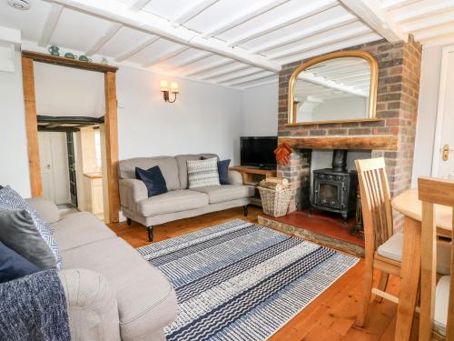 a living room with a couch and a fireplace at Fisherman's Cottage in Pevensey