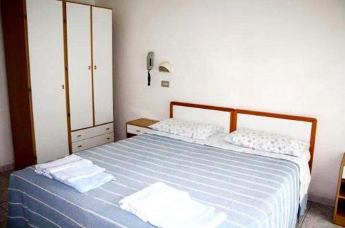 a bedroom with a blue bed with two towels on it at Hotel Delizia in Rimini