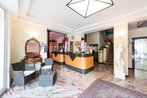 un salone con bancone, sedie e specchio di Hotel Delizia a Rimini