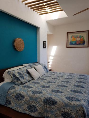 a bedroom with a blue wall and a bed with pillows at Bella Casa Privada junto al Mar Caribe in Cancún