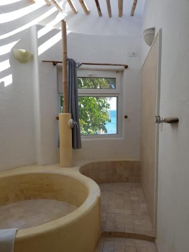 a bathroom with a tub in a room with a window at Bella Casa Privada junto al Mar Caribe in Cancún