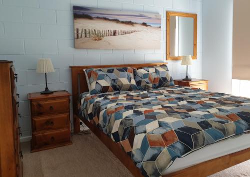 Marion Bay的住宿－馬里恩灣假日公園，一间卧室配有一张床、两个床头柜和一张四柱床