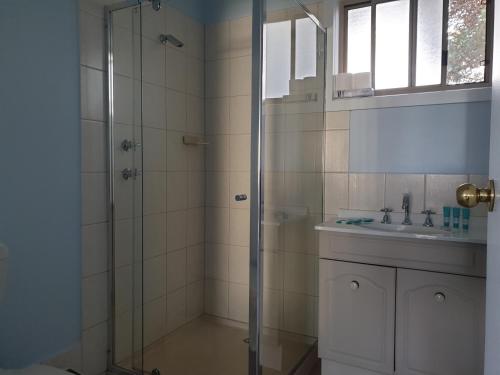 a bathroom with a glass shower and a sink at Marion Bay Holiday Villas in Marion Bay