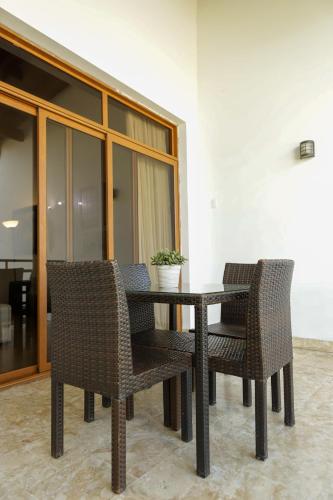 a table and chairs with a potted plant on it at Sybaris Suites & Residences in Juan Dolio