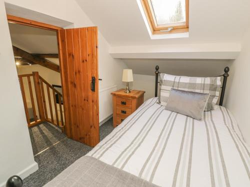 sypialnia z łóżkiem i drewnianymi drzwiami w obiekcie Crud yr Awel w mieście Bangor