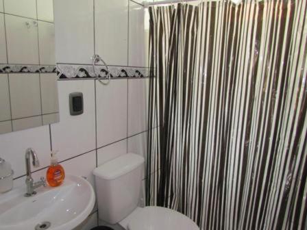 baño con cortina de ducha en blanco y negro en Moradas Dias, en Florianópolis