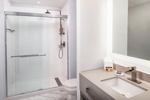 a bathroom with a shower and a sink and a toilet at River Street Inn in Savannah