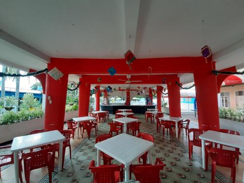a restaurant with red columns and tables and chairs at Hotel Sael in Tocaima