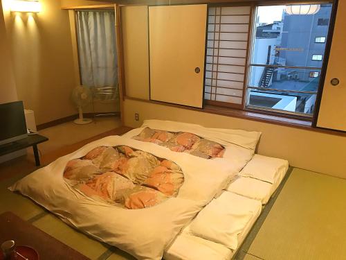 Postel nebo postele na pokoji v ubytování Osaka Ryokan Kuramoto