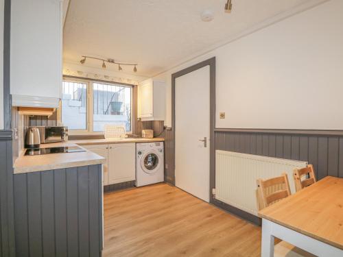 a kitchen with a washer and dryer in a room at The Neuk in Elgin