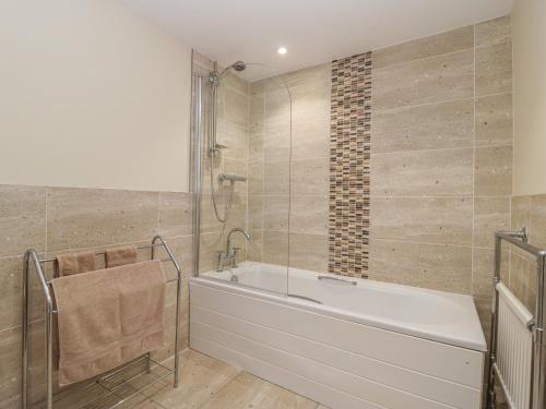 a bathroom with a bath tub and a shower at Park Road Apartment in Harrogate