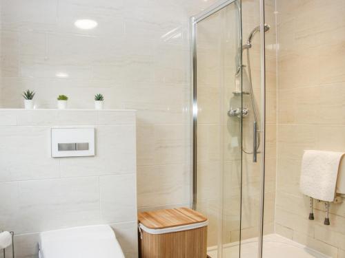 uma casa de banho com um chuveiro e uma cabina de duche em vidro. em Court Farm em Kidderminster