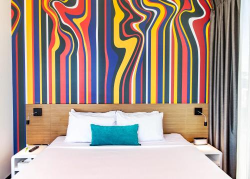 a bedroom with a bed and a colorful wall at ibis Styles Brisbane Elizabeth Street in Brisbane