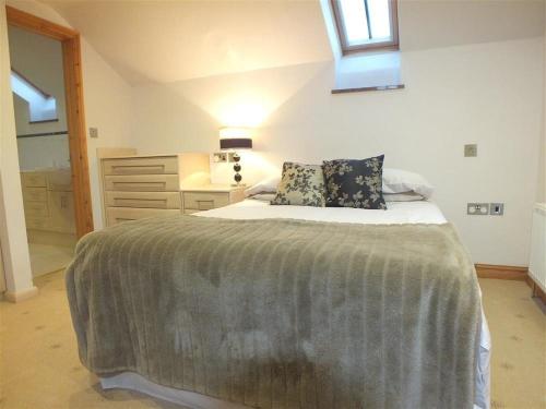 a bedroom with a bed and a dresser and a window at Cable Cottage in Fishguard