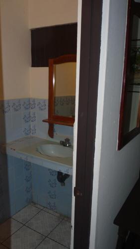a bathroom with a sink and a mirror at Hotel Arboleda in Quepos