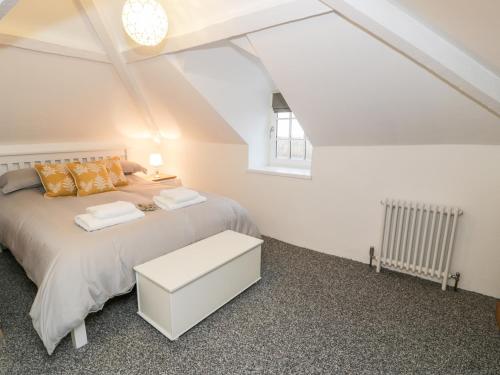 a white bedroom with a bed and a window at Pentowyn in Holyhead