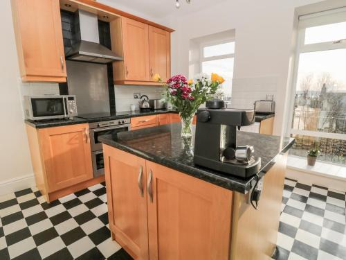 a kitchen with a counter with a flower vase on it at Tynemouth Village Penthouse in North Shields