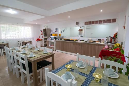 a kitchen and dining room with a table and chairs at Pousada Vovó Dilma in Penha