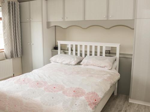 a bedroom with a white bed with pink flowers on it at Castle View in Oughterard