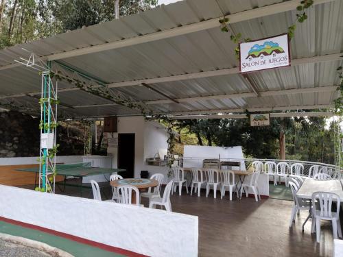 a group of tables and chairs under a pergola at Hotel Cabañas El Rincón de las Campanas in Nobsa