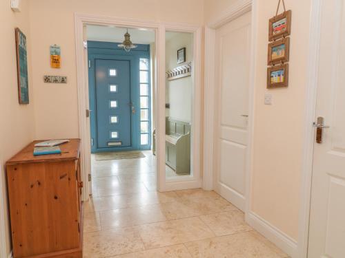 a hallway with a blue door and aoyer with a floor at Atlantic Reach in Bude