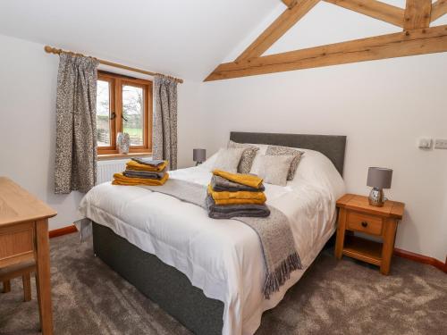 a bedroom with a bed with yellow pillows on it at The Old Cart House in Oswestry