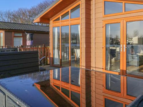 a house with glass doors and a patio at Shore Beats Work - Capenwray 10 in Carnforth