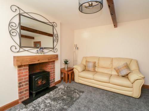 a living room with a couch and a fireplace at 2 Whiterow in Powfoot