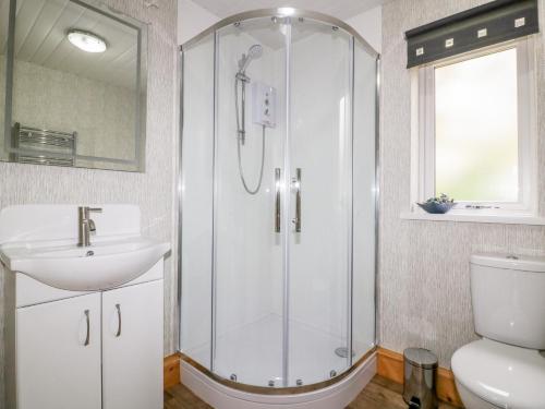 a bathroom with a shower and a sink and a toilet at Lodge One in Truro