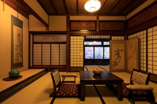 a living room with a table and chairs and a window at Yumoto Choza in Takayama