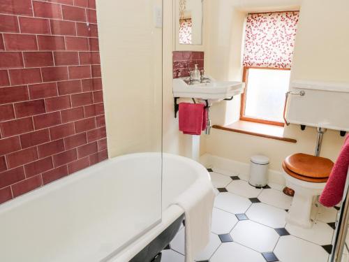 a bathroom with a tub and a sink and a toilet at Foxglove in Keighley