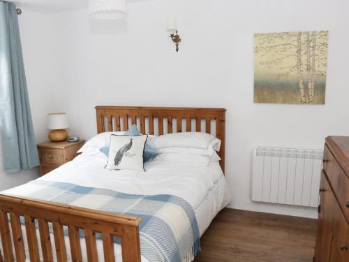 um quarto com uma cama com uma cabeceira de madeira em An Teach Ban em Rossaveel