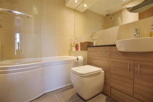 Un baño con bañera, inodoro y lavabo. en Gwelfor, Newport, en Newport