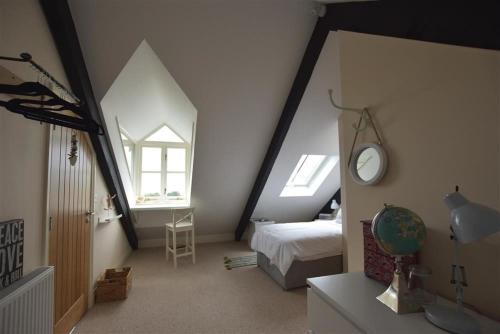 Un dormitorio abuhardillado con una cama y un espejo. en Gwelfor, Newport, en Newport