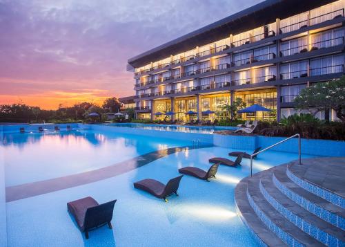 a hotel with a large swimming pool with chairs at Swiss-Belresort Belitung in Tanjungbinga