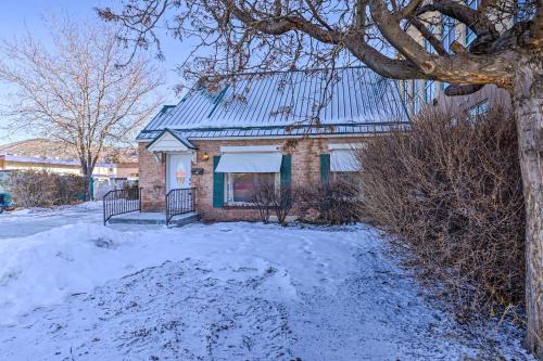 a brick house with a metal roof in the snow at Downtown Cedar City House Less Than half Mi to SUU Campus! in Cedar City