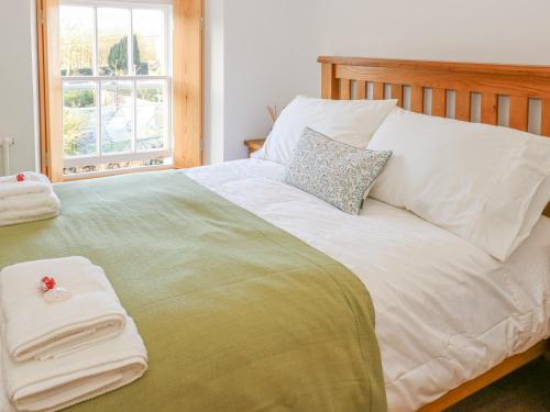 a bedroom with a large bed with towels on it at Howgill Cottage in Sedbergh