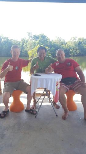 a group of three men sitting around a table at Khum Thong Resort in Takua Pa
